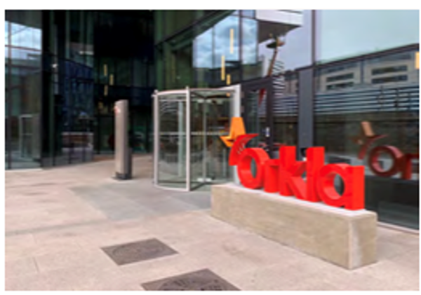 Inngangspartiet til Orklas hovedkontor i Oslo med glassfasade og rød Orkla-skulptur.